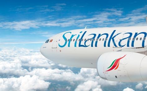 SriLankan Airlines plane flying above clouds with blue sky background.